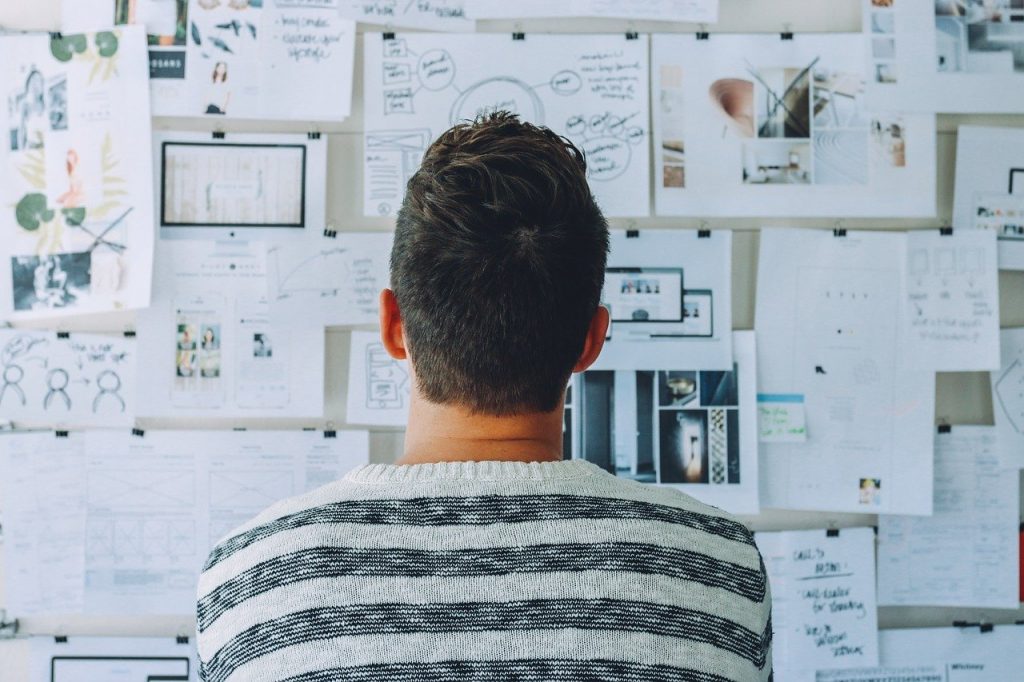 Man looking at papers on the wall