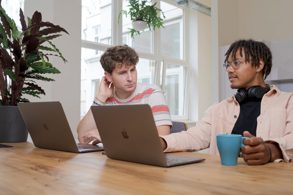 Two young man on laptops